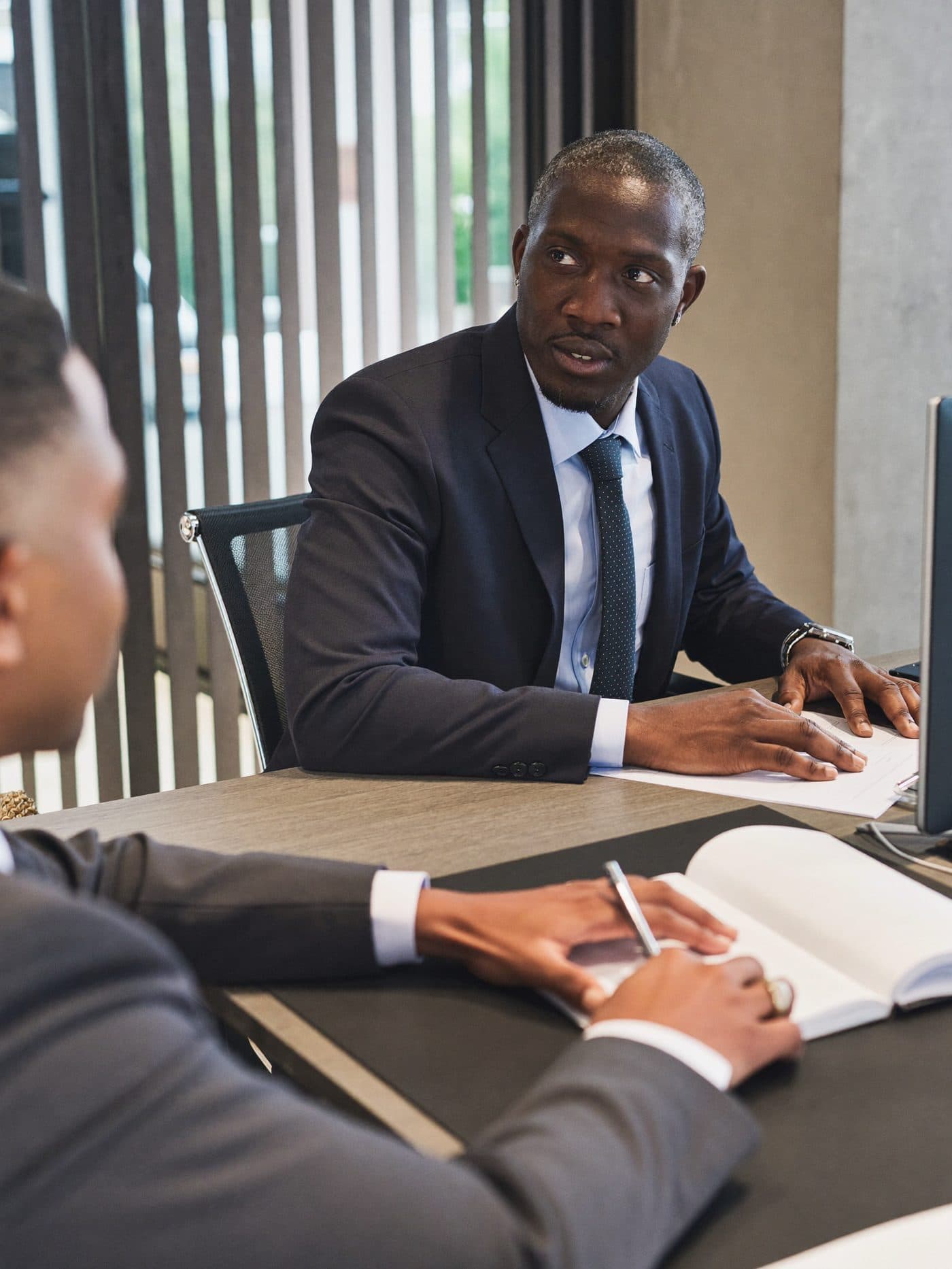 Financial advisor talking with a customer across a desk in a bank branch