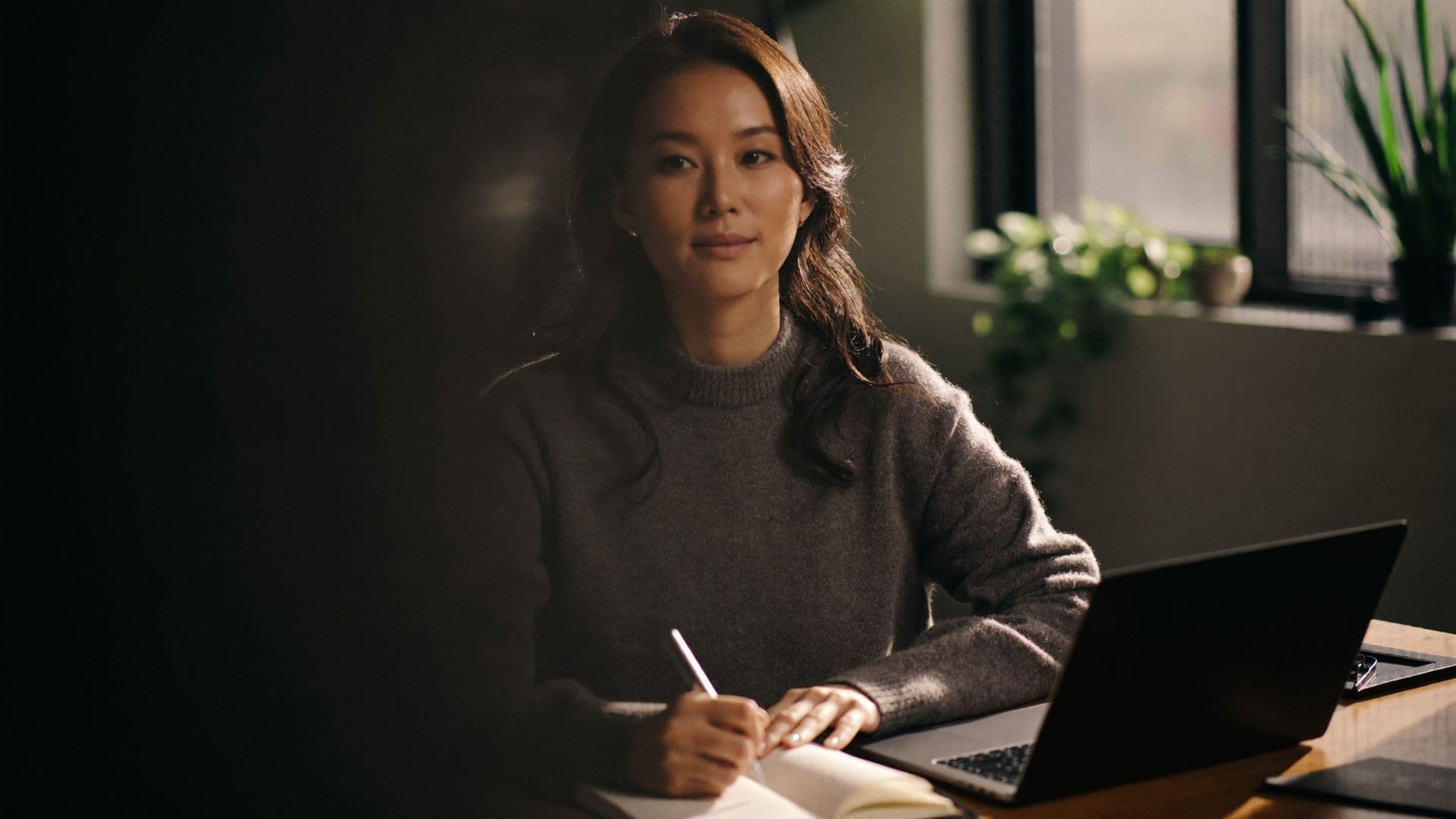 Head of HR writing notes at a wooden desk